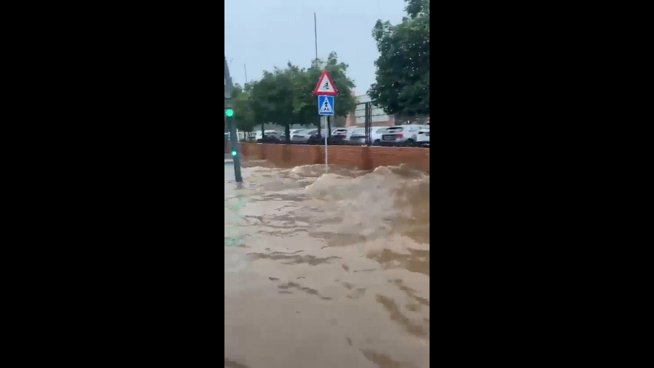 Bus struggles through deep floodwaters at Plaza de la Diversión in Seville, Spain