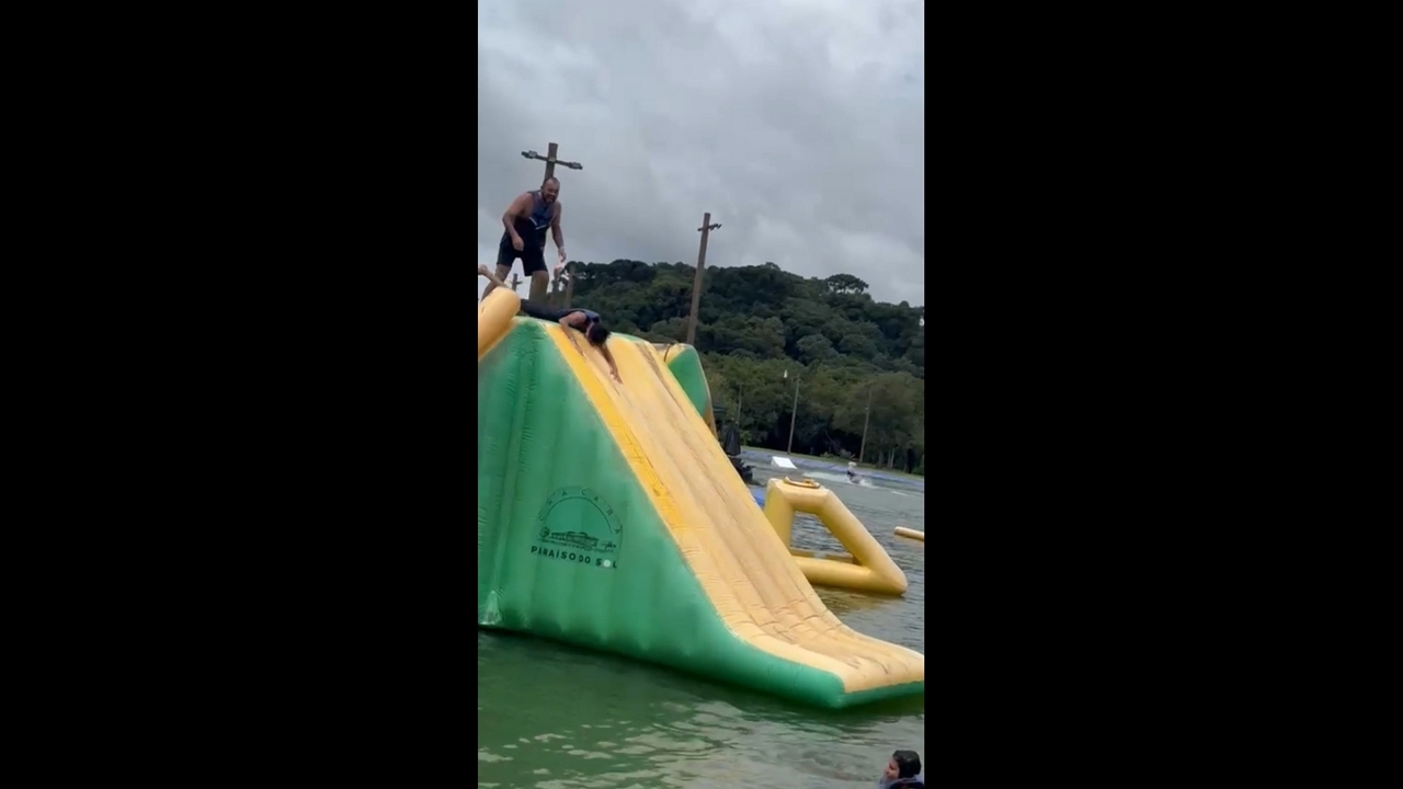 Excited rider slips before inflatable water slide in Campo Largo, Paraná, Brazil