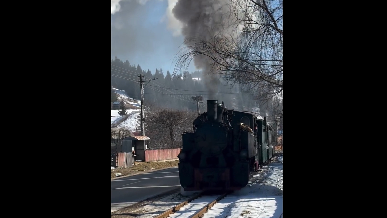 Narrow-gauge steam train passes through Moldovița, Romania