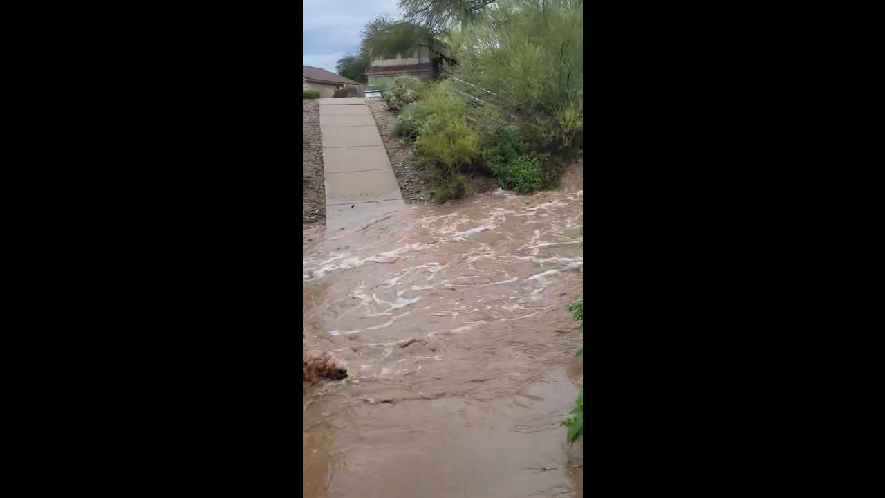 Heavy rain sends floodwaters rushing through a desert wash in Scottsdale, USA