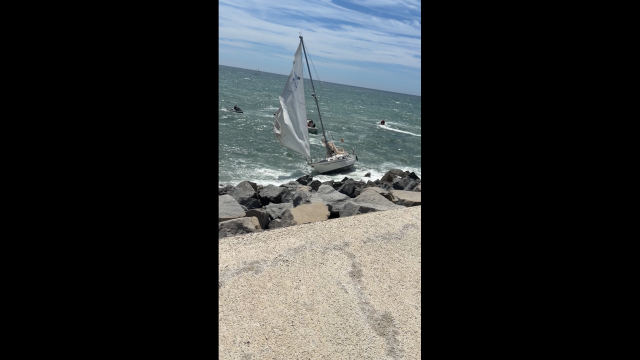 Rough seas batter grounded sailboat off coast of Mataró, Spain