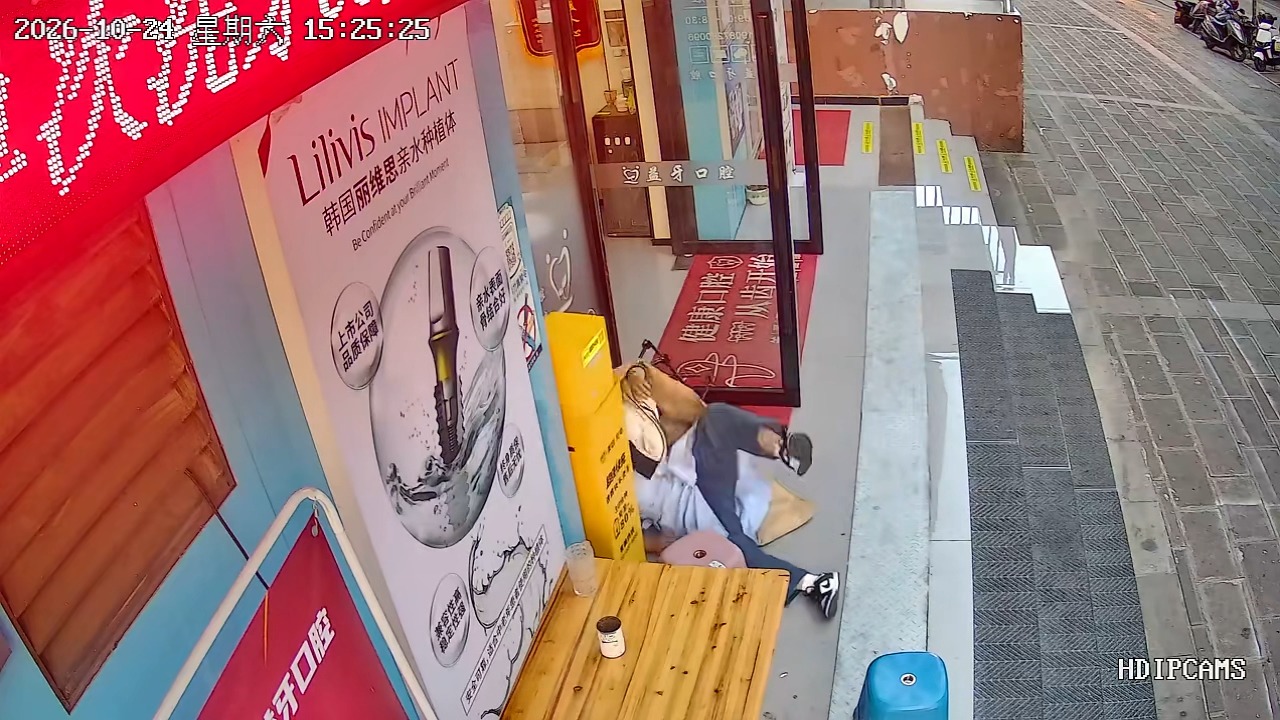 Folding chair collapses beneath woman outside a dental clinic in Guangdong, China