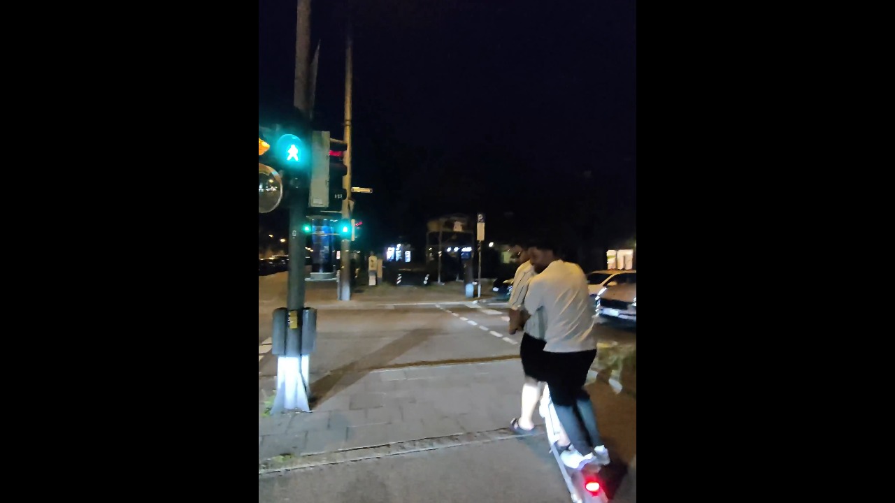 Three friends narrowly avoid a turning car while riding an e-scooter in Munich, Germany