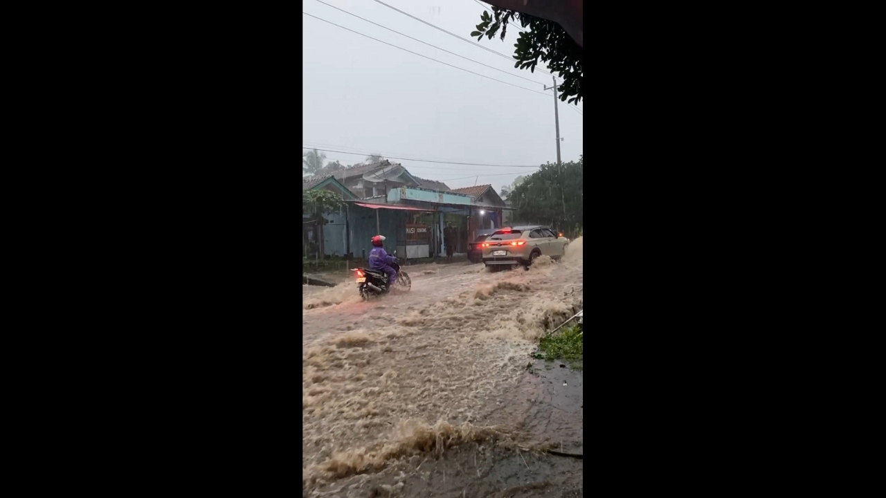 Fast-moving floodwaters sweep across Bojong–Guci highway in Tegal, Indonesia