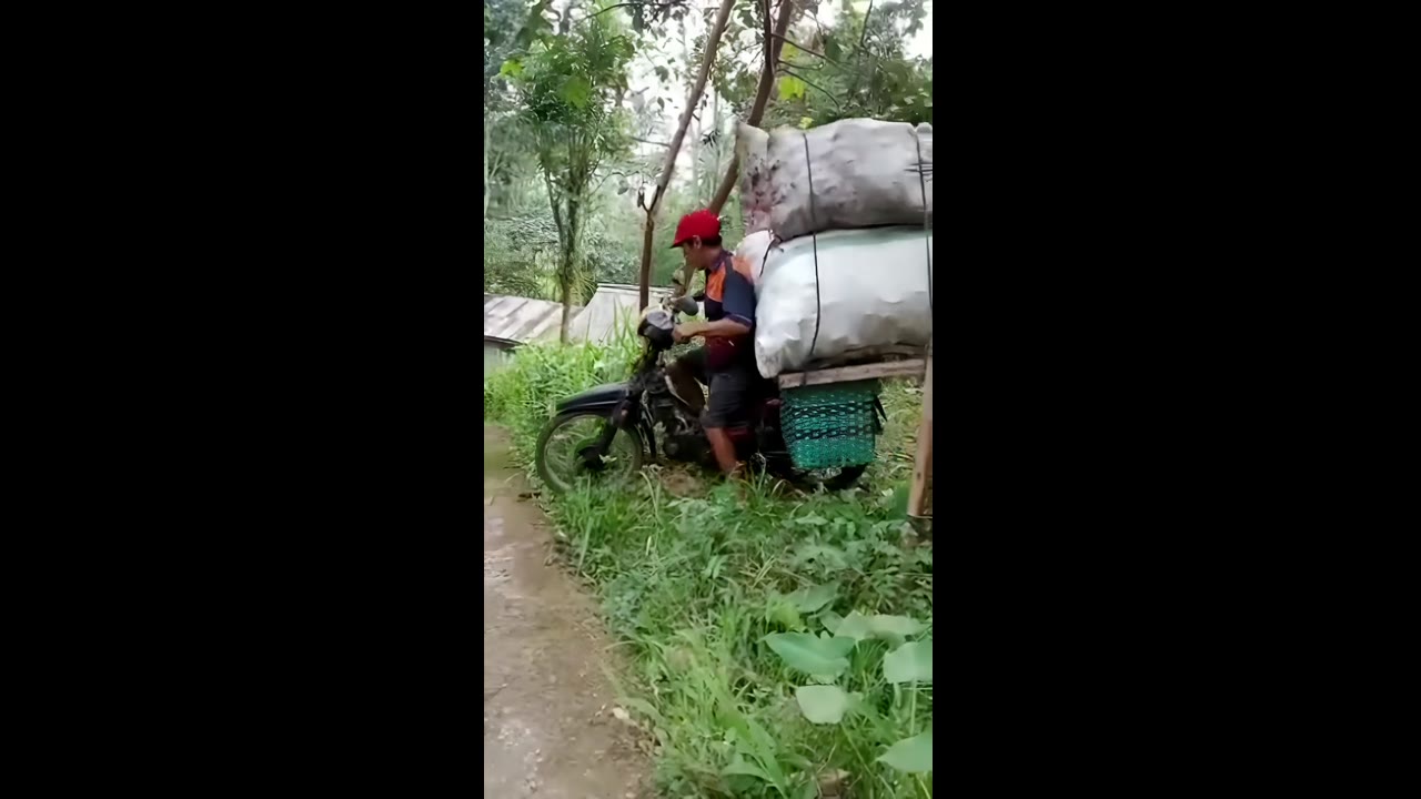 Overloaded motorbike sends friend tumbling in Yogyakarta, Indonesia