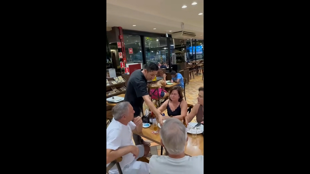 Server startles customer after dropping a fake beer mug on a table in Foz do Iguaçu, Brazil