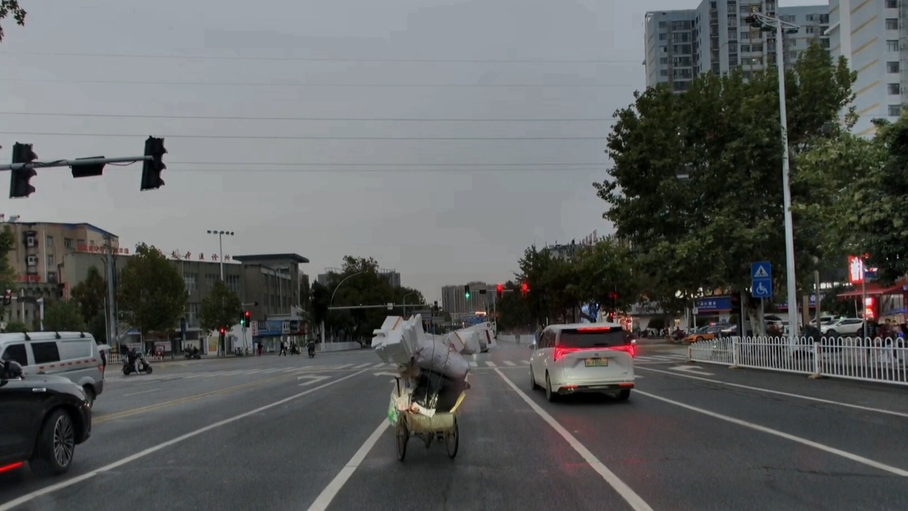 Driver narrowly avoids collision with elderly woman pushing loaded cart in Hubei, China