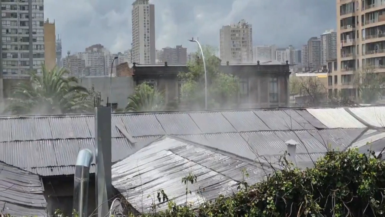 Steam rises from rooftops as sunlight evaporates rainwater in Santiago, Chile