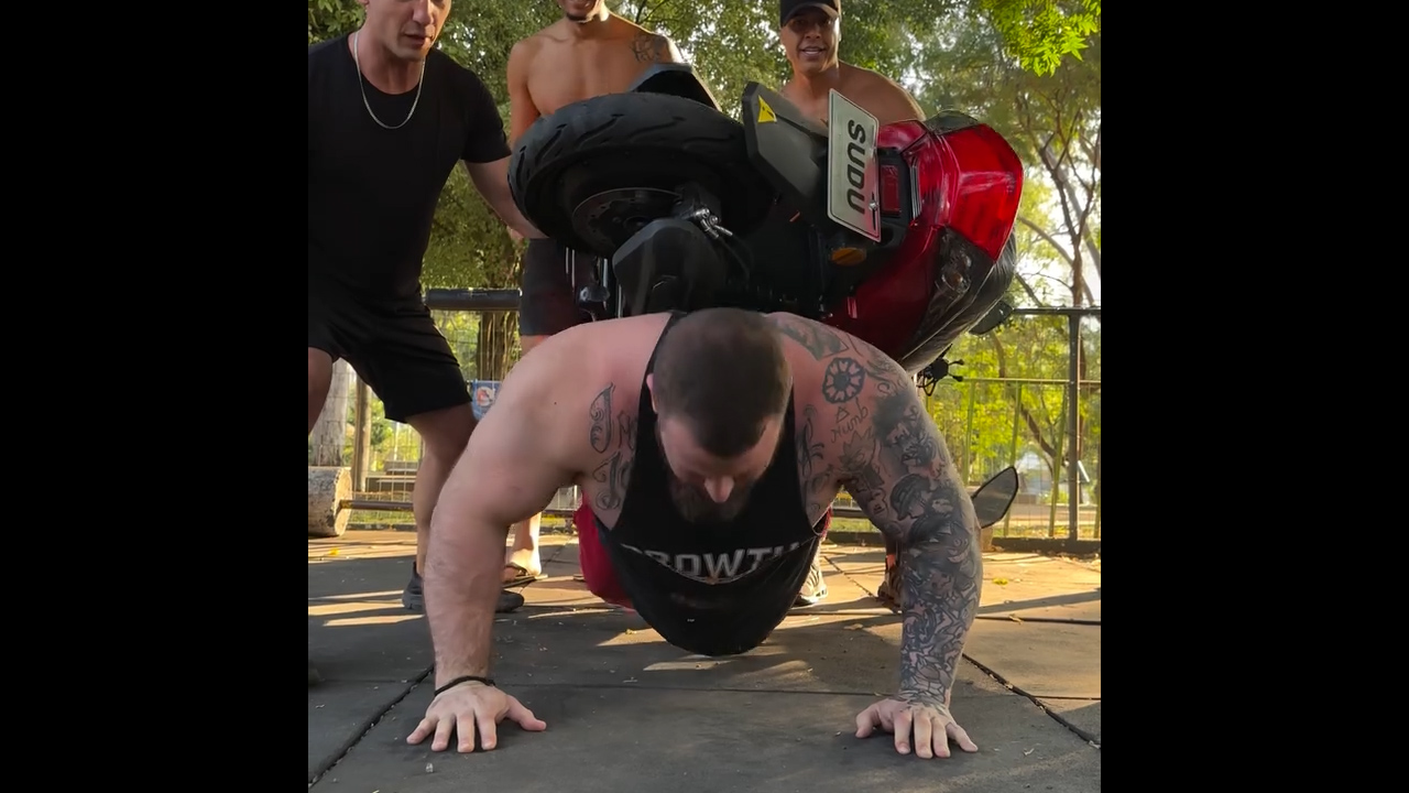 Man performs push-ups with motorcycle on his back in São Paulo
