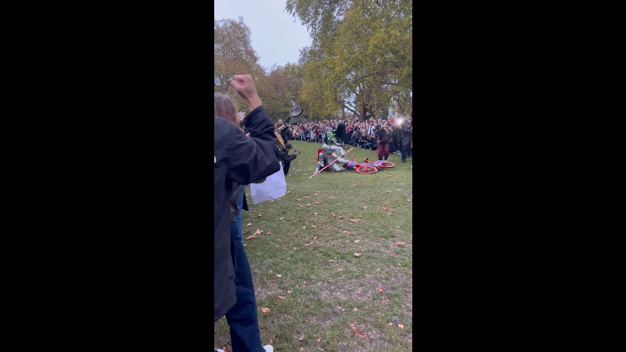 Men in medieval armor stage a jousting duel on Lime e-bikes in London Fields, UK