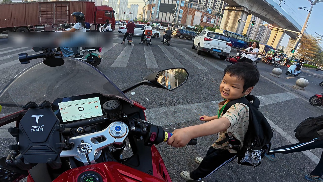 Student playfully twists motorcycle throttle at intersection in Guangdong, China