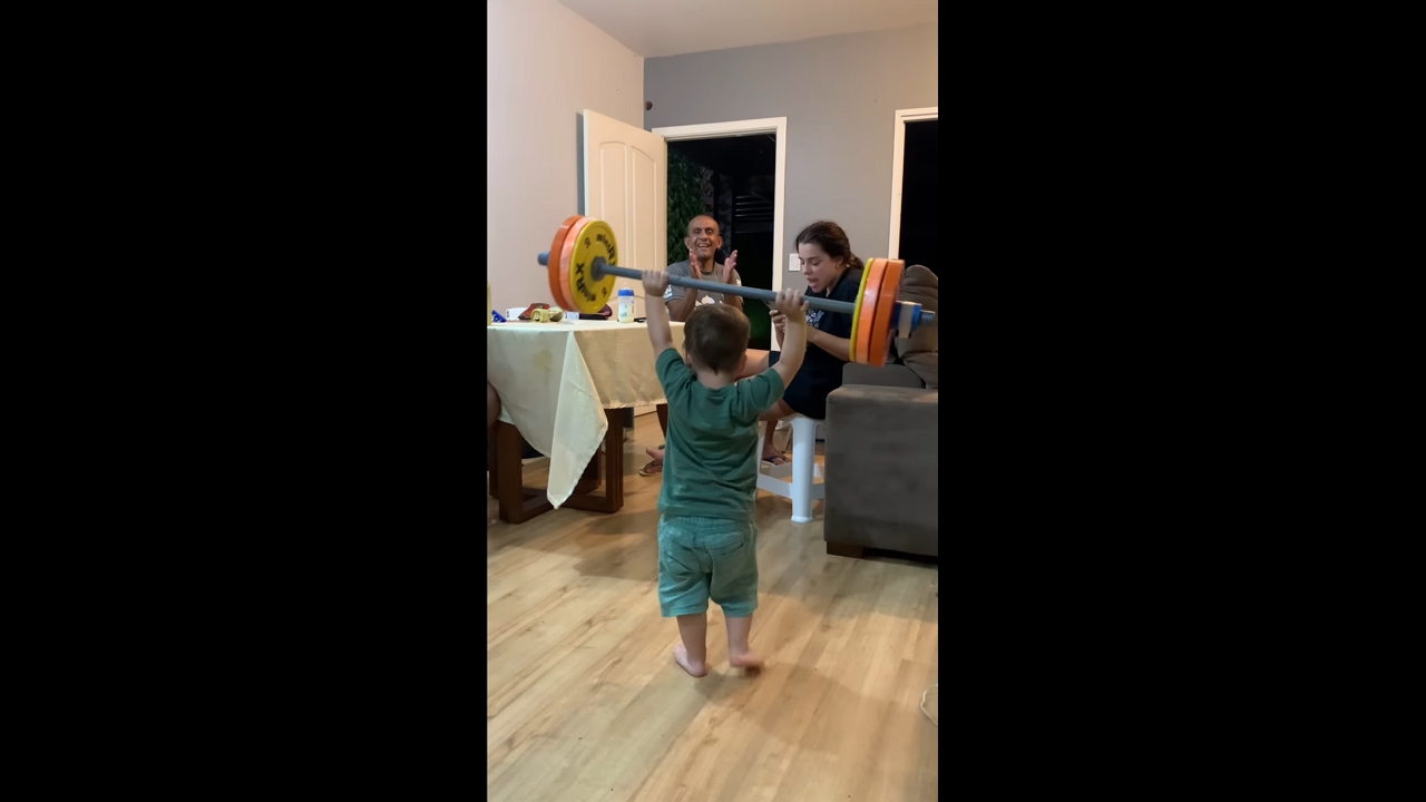 Young boy shows strength lifting barbell in Brasília, Brazil