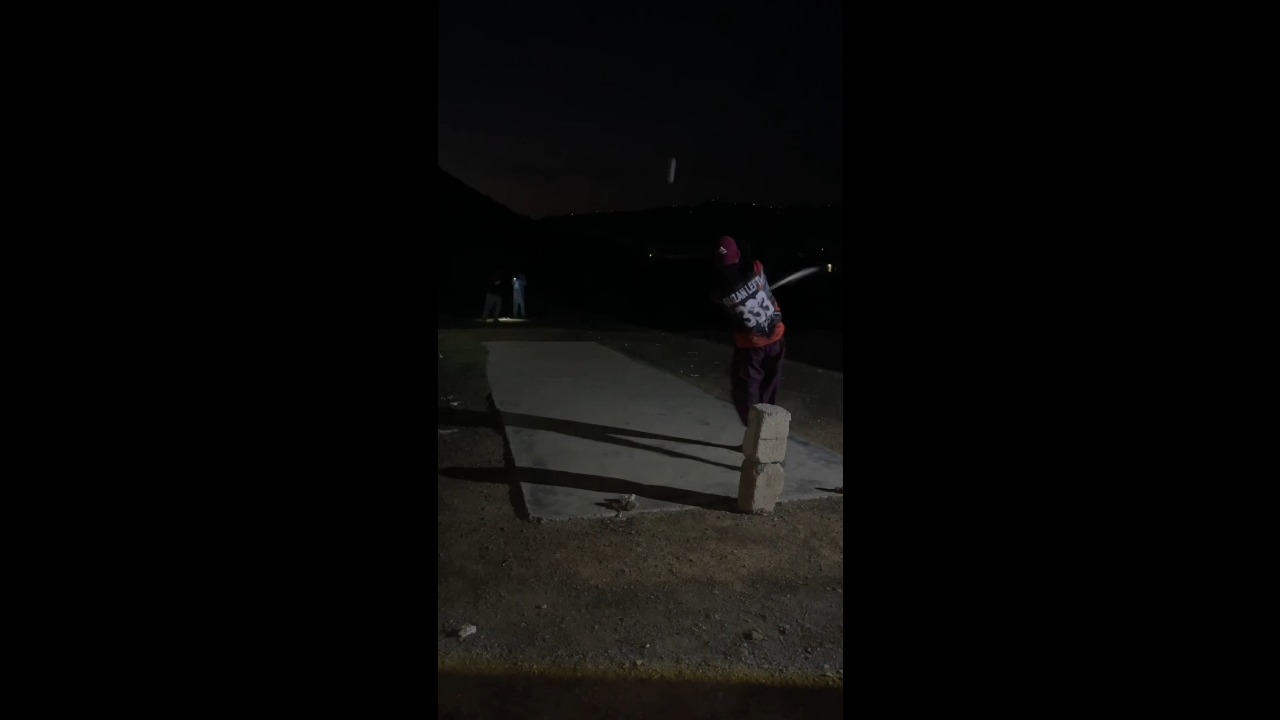 Cricket match continues under flashlights after a power outage in Haripur, Pakistan