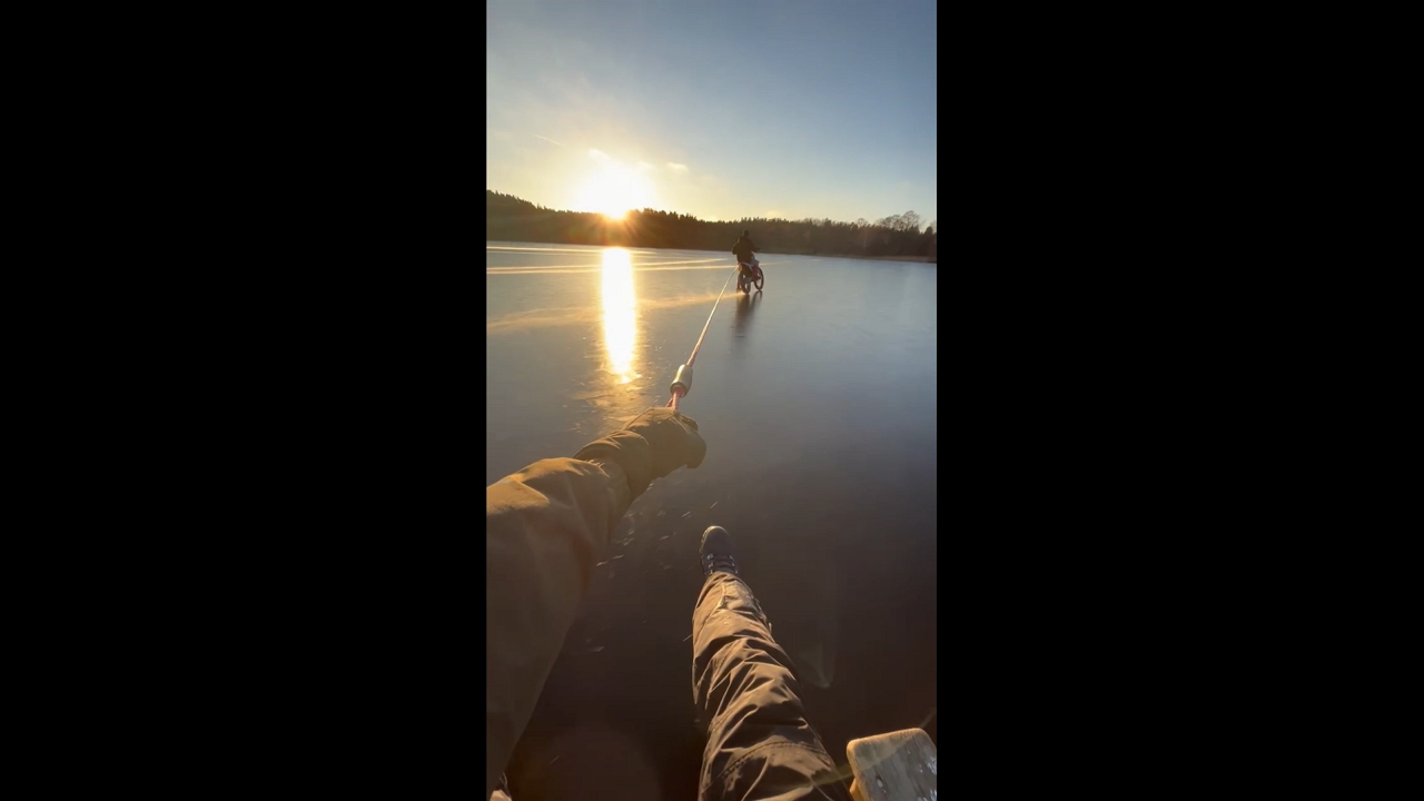 Friends slide across frozen lake in Järna, Sweden