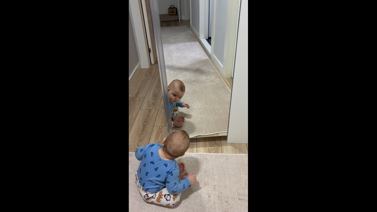 Baby delighted by own reflection in İzmir, Turkey