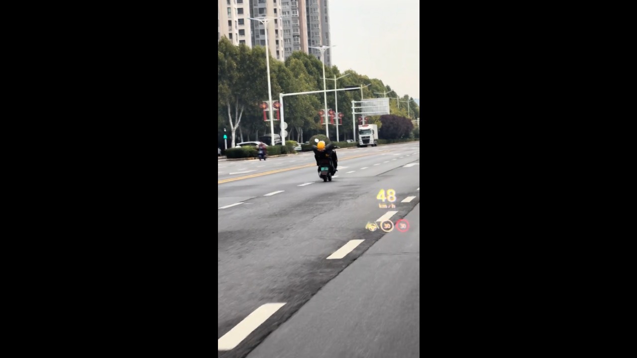 Meituan rider spotted riding a motorcycle in a reclined position on a busy road in Zhengzhou, China