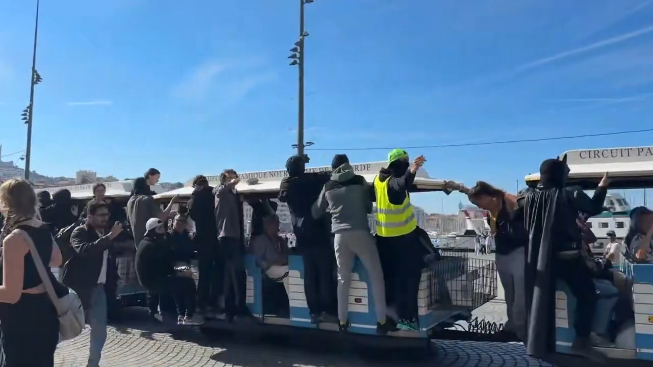 Protesters gather around a tourist road train during a street demonstration in Marseille, France