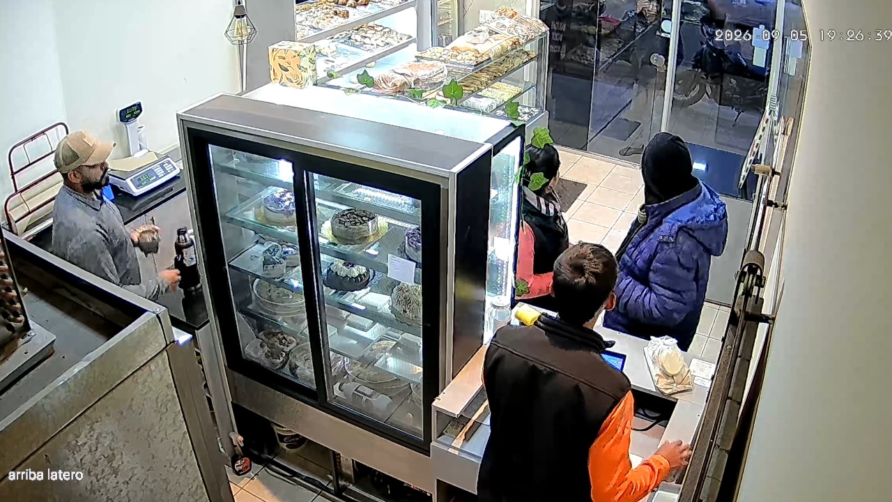 Customer struggles to open push door at cake shop in Mendoza, Argentina