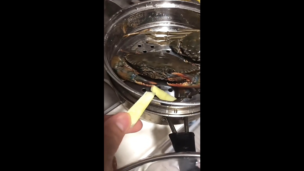 Crab suddenly clamps onto a hand while being offered fruit in Guangdong, China