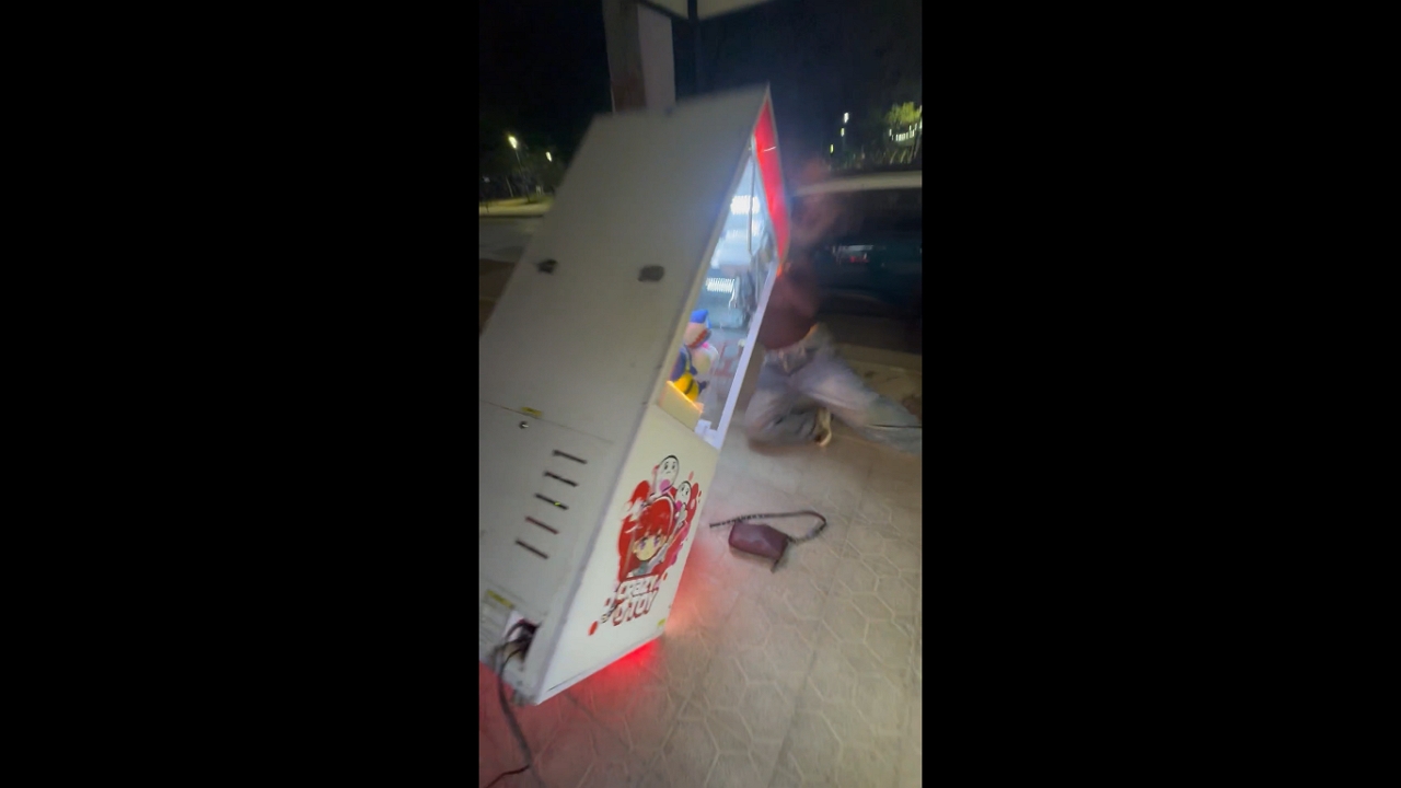 Woman accidentally topples claw machine while trying to win stuffed toy in Orán, Argentina