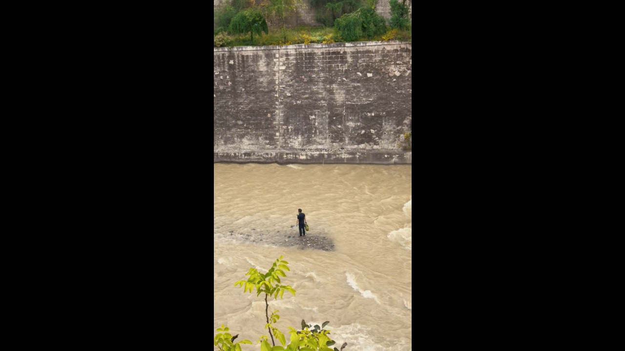 Man rescues stranded puppy from fast-flowing river in Longnan, China