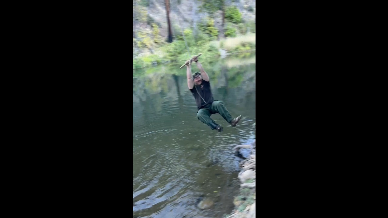 Friends work together to rescue man struggling on a rope swing over a river in Quincy, USA