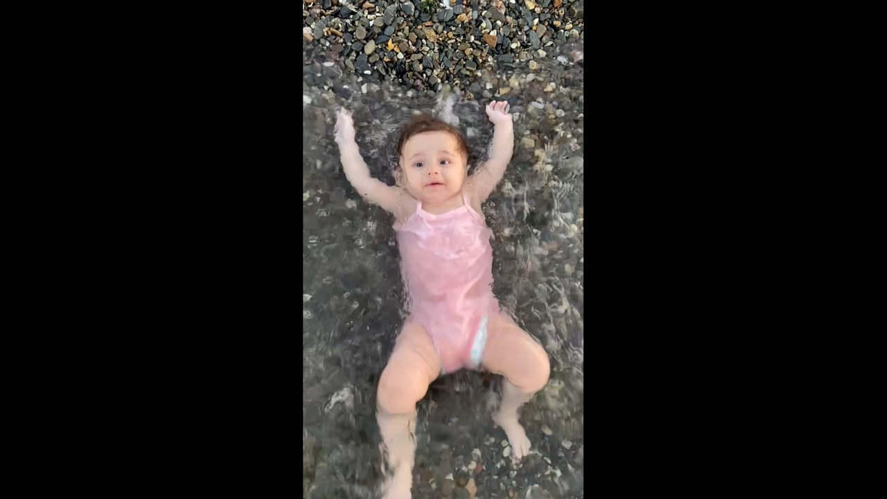Baby gently lifted by wave on the shore in İzmir, Turkey