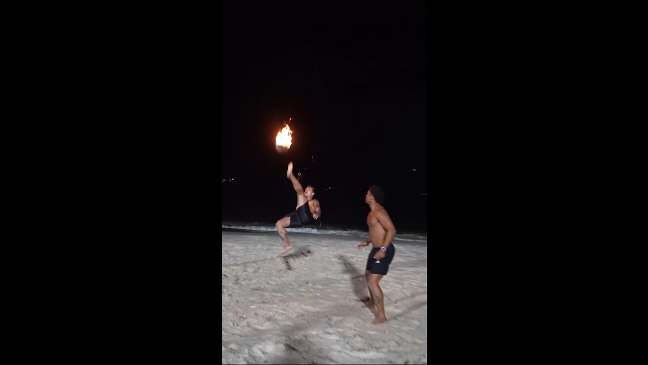 Friends play fiery beach ball game in Niterói, Brazil