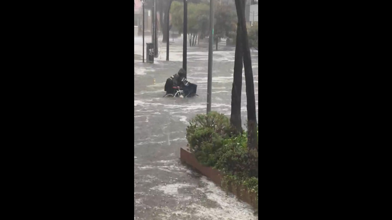 Flash flooding sweeps vehicles through hail-covered streets in Quito, Ecuador