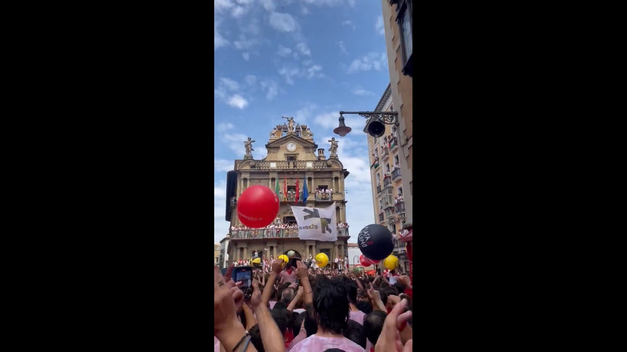 Crowd celebrates San Fermín at Town Hall Square in Pamplona, Spain
