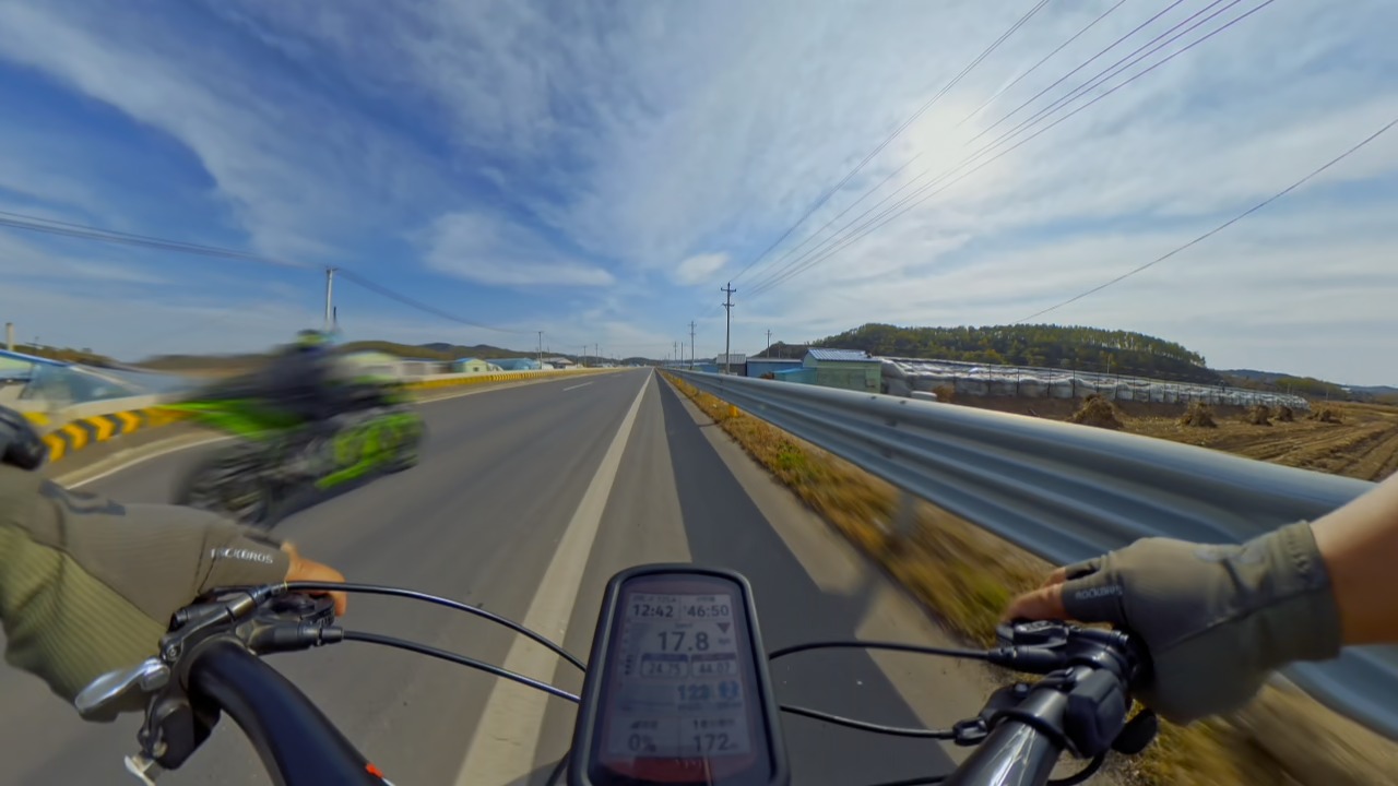 Motorcycles roar past a cyclist at high speed on a provincial road in Liaoning, China