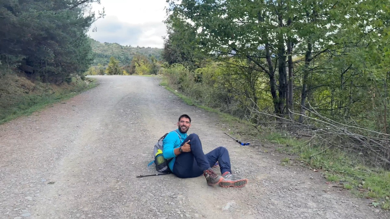 Man trips over his own walking stick while pretending to fly on a hiking trail in Alicante, Spain