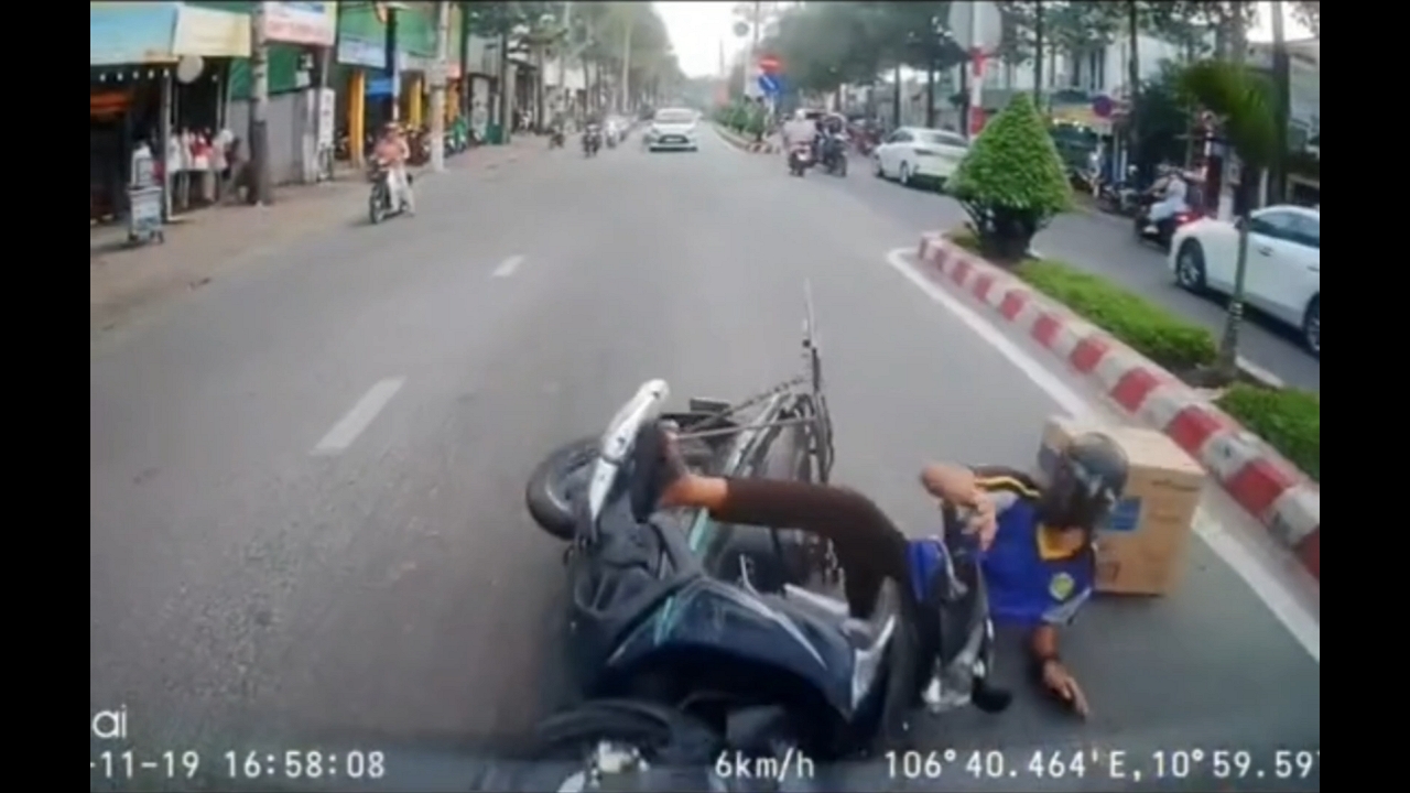 Rider crashes and falls while distracted in Thủ Dầu Một, Vietnam