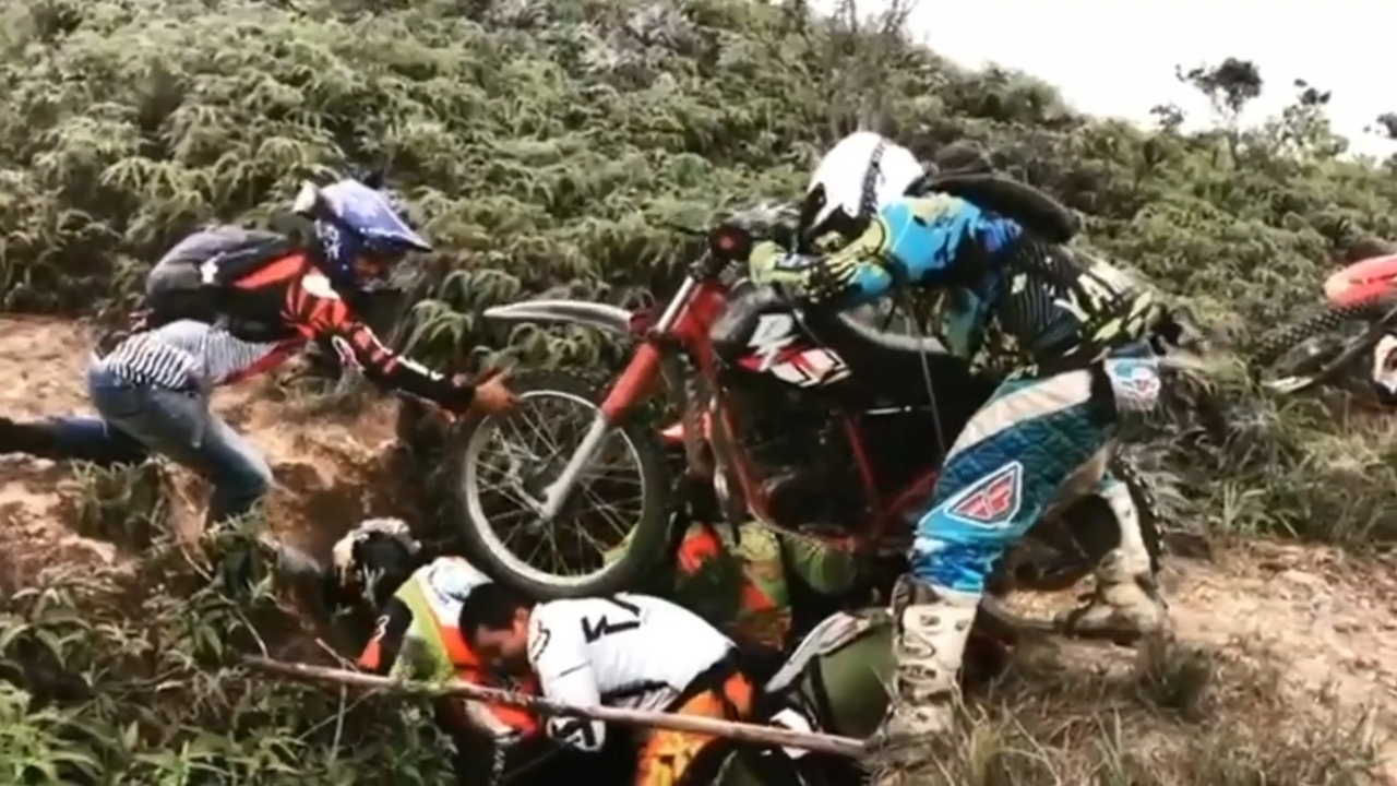 Men form human bridge to cross motorcycle in Garzón, Colombia
