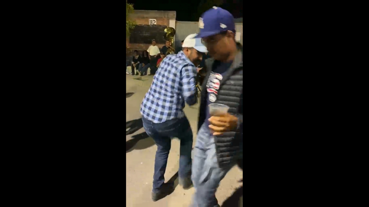 Dancing man slips while holding drink on street in San Francisco del Rincón, Mexico