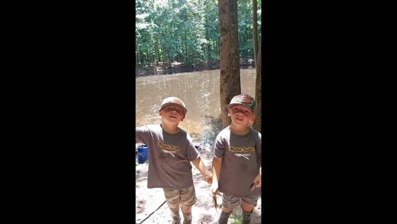 Twin boys show off their catch during fishing trip in North Alabama, USA