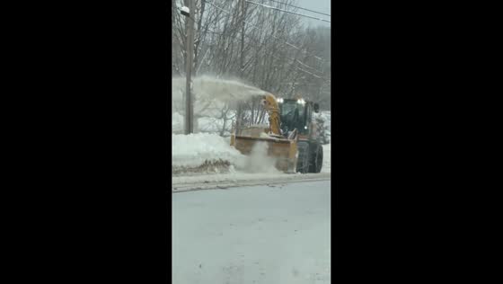 Snow loader clears towering banks after lake-effect snow in Altmar, New York, USA