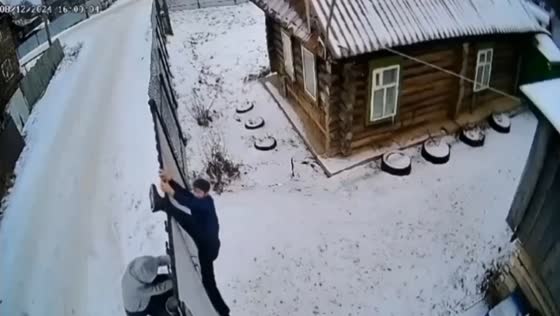 Drunk men struggle with a fence in Yanaule, Russia