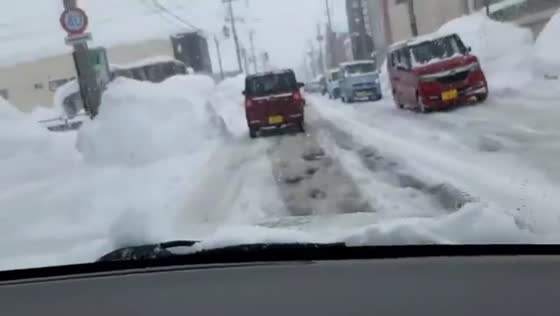Massive snowbanks narrow roads after historic snowfall in Hirosaki, Aomori, Japan