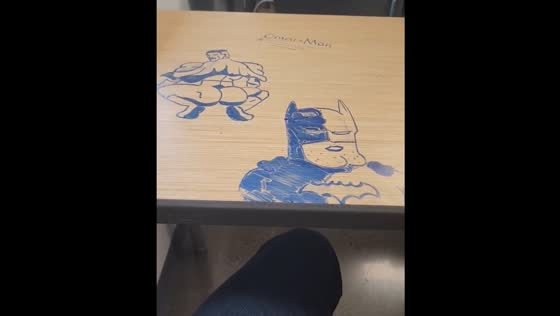 Student draws Omni-Man and Batman on desk during Spanish class