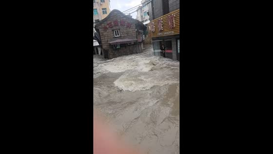 Powerful floodwaters surge through narrow street in Zhejiang, China
