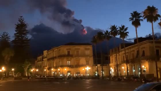 Mount Etna emits black smoke seen from Piazza del Duomo, Giarre