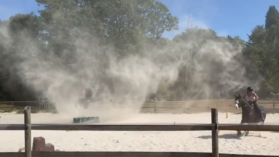 Dust devil sweeps through equestrian riding arena during riding lesson in Rouvres, France