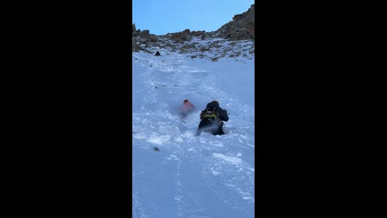 Hiker intercepts friend sliding uncontrollably down snow mountain in Ningxia, China