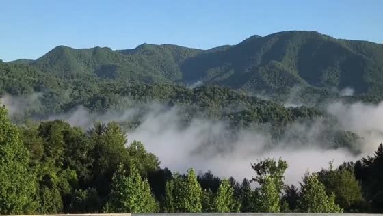 Fog drifts across mountain range at sunrise in Weaverville, North Carolina, USA