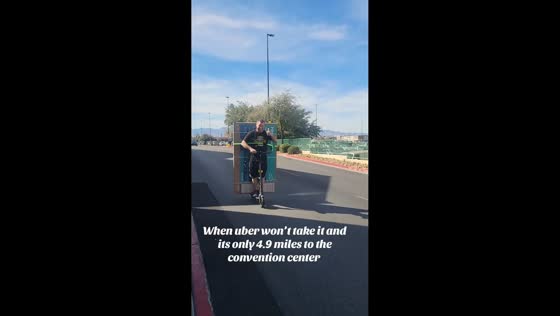 Man rides electric scooter carrying TV in Las Vegas, Nevada, USA