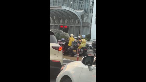 Happy scooter riders waiting at traffic light in Shandong, China