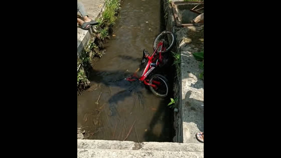 Playful mishap sends bicycle into ditch in Tasikmalaya, Indonesia