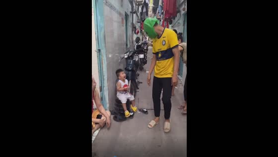 Unexpected overwhelm: child's tearful reaction to a playful encounter with a green frog mask!