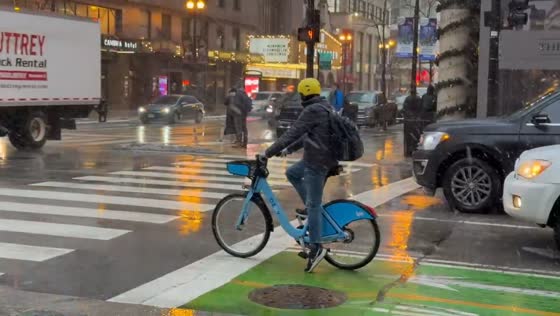 Cyclists and pedestrians navigate rainy streets in Chicago, USA